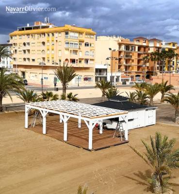 Chiringuito con pergola de madera y pasarela de acceso