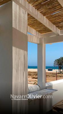 Pérgola de madera laminada blanca con cubierta en cañizo