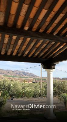 Pérgola clasica de madera laminada sobre pilares prefabricados de cemento con cubierta en teja vista