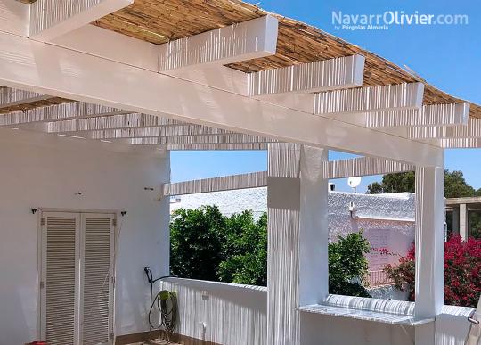 Pérgola de madera blanca con cubierta de cañizo