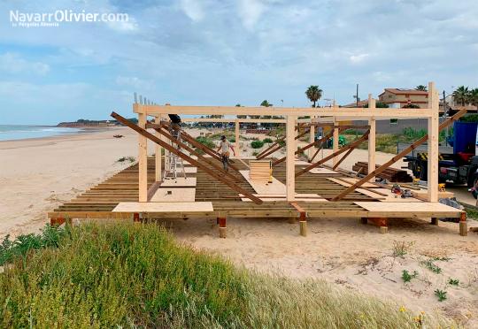 Montaje de restaurante de playa sobre pilotes de madera hincados en la arena