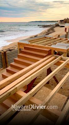 Montaje de terraza sobre pilotes con escalera en madera de iroko