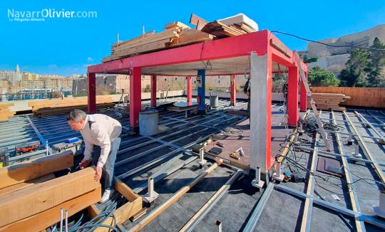 Construcción de restaurante en azotea de edificio. Deckin de madera tratada sobre forjado metálico