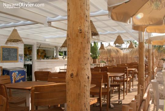 Pérgola de tronco descortezado y madera porta toldo