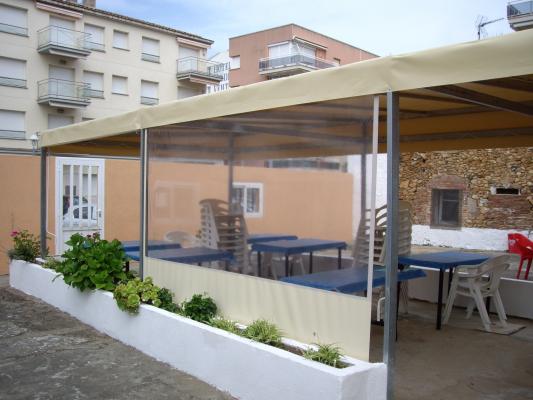 terraza restaurante: estructura con toldo pvc tensado y toldos verticales anti-viento 
