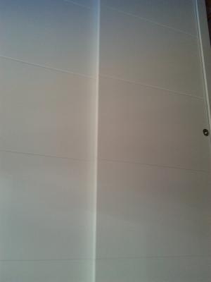 Frente de armario de 2 puertas correderas de suelo a techo con franjas horizontales lacadas blanco