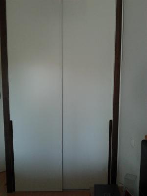 Frente puertas correderas suelo techo llacado en blanco con laterales y tiradores en nogal americano