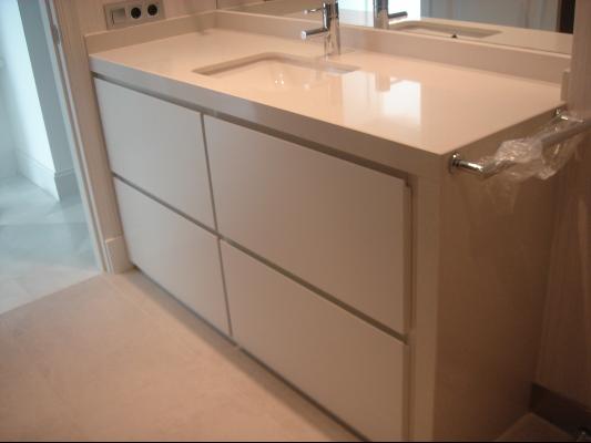 Encimera y costado mueble baño en Compacto Blanco.
