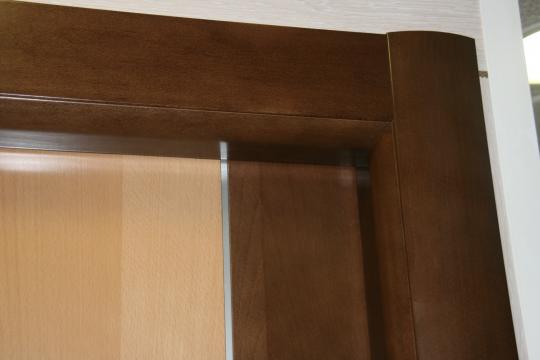 Puertas Dominguez®: Detalle del Sistema de unión sin clavos entre marco y tapajuntas en madera natural de haya maciza tintada nogal - DDS diseño curvo