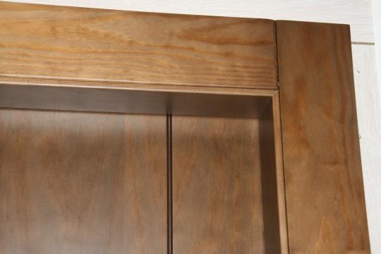 Dom®: Detalle del Sistema de unión sin clavos entre marco y tapajuntas en madera natural de pino macizo tintado en embero- DDS diseño liso