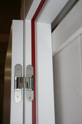 Domporte®: Detalle de bisagra oculta regulable en tres direcciones en una puerta cortafuegos EI30