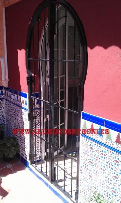 Puerta reja de hierro con forma de arco árabe
