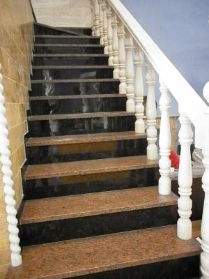 escaleras en marrón y granito rosa