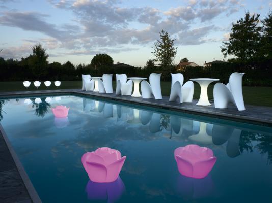 Flores iluminadas flotando en el agua de la piscina. 
