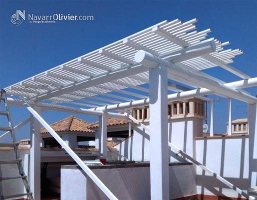 Montaje de pergola para azotea construida en palo redondo y cubierta en listones. navarrolivier.com