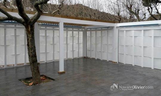 Pérgola perimetral construida en madera tratada con muro en microperforado. Gerona