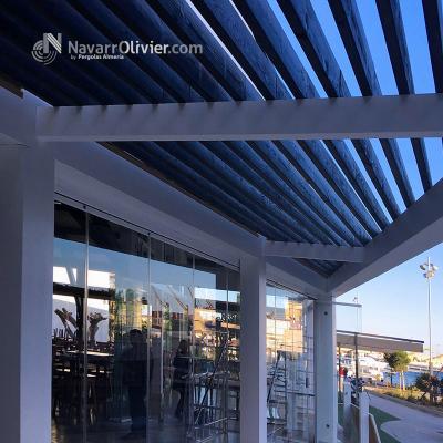 Estructura de madera en color blanco con cubierta de luz filtrada formada por vigas de madera t