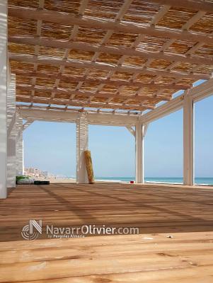 Terraza de chiringuito con suelo en tarima autoclave, Pergola en vigas y palo redondo con cubierta e
