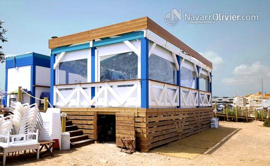 Chiringuito con pérgola ya aseos sobre plataforma pilotada de madera tratada en autoclave