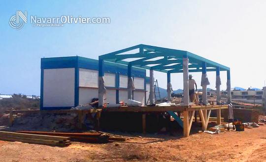 Montaje de chiringuito con pergola y aseos sobre superficie pilotada con rampa de acceso.