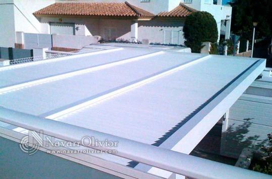 Pérgola de de madera acabada en blanco con cubierta de luz filtrada